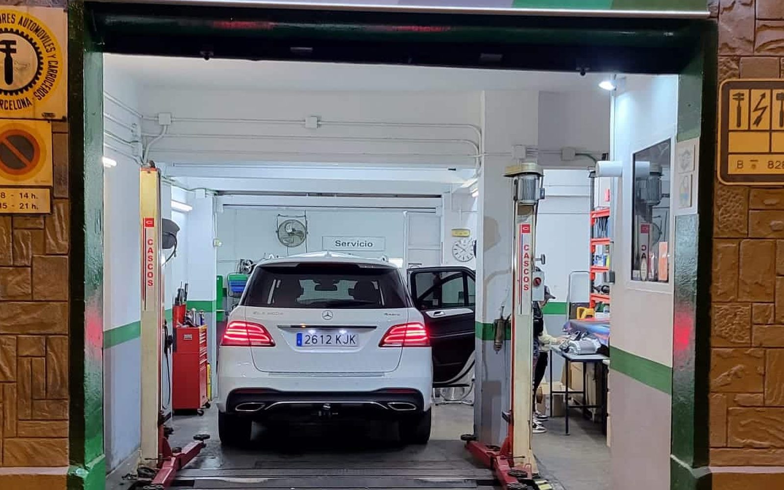 Coche en el elevador de Taller Garrido visto desde la calle