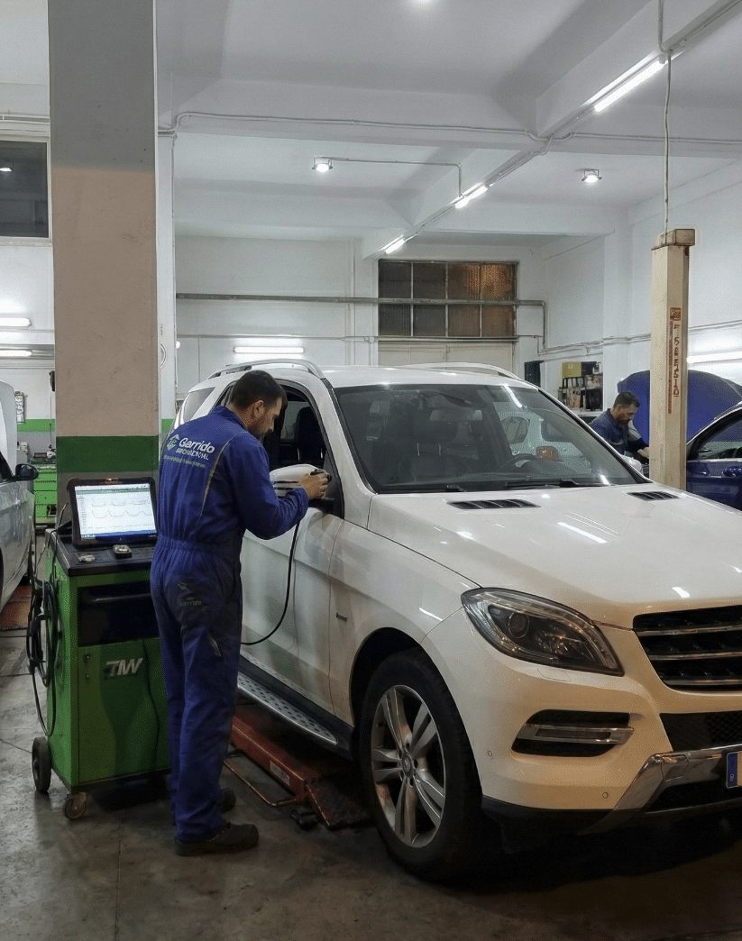 Técnico de Taller Garrido con el equipo de diagnosis junto a un coche