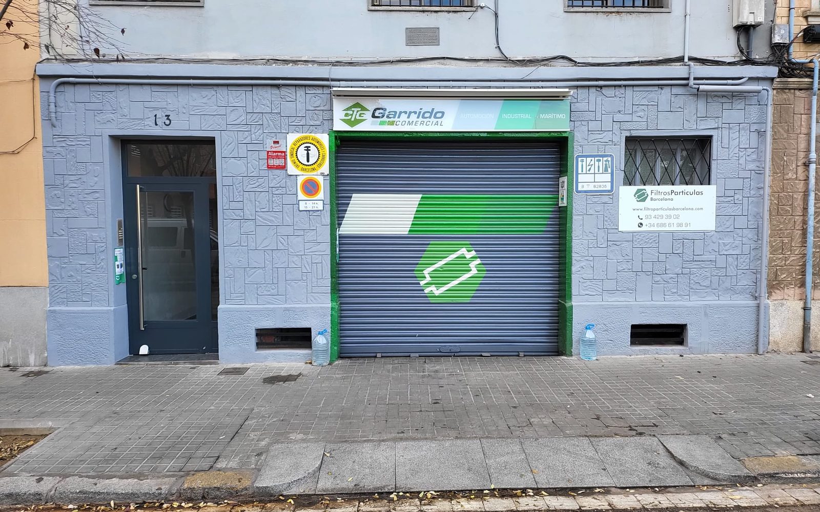 Fachada de Taller Garrido con la persiana bajada, Carrer de l'Escultor Llimona 13